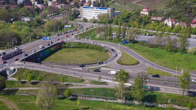 Aerial view of heavy traffic on a complex highway interchange in the Prague-Troja district with city infrastructure and residential buildings in daylight