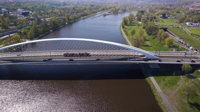 Aerial view of modern Troja Bridge with public transport tram and bus crossing Vltava river toward Hole&scaron;ovice district in Prague on a sunny day