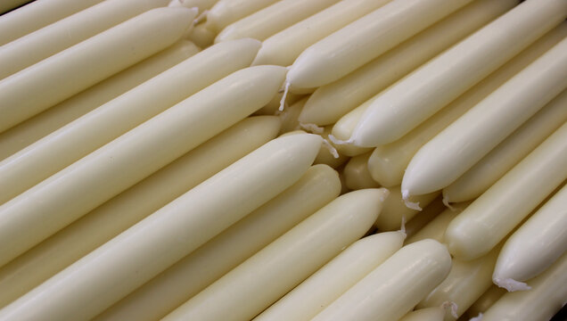 New natural colored paraffin candles are stacked before packaging after production
