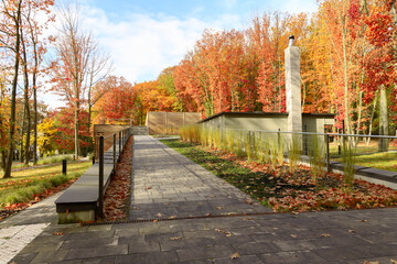 Naklejka premium Modern building nestled in a vibrant autumn forest with colorful foliage
