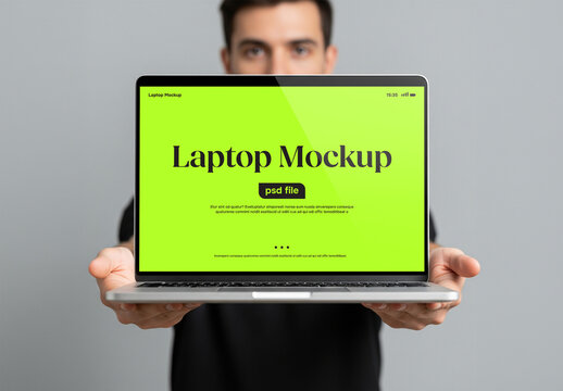 A man holding a laptop in front of him for a mockup