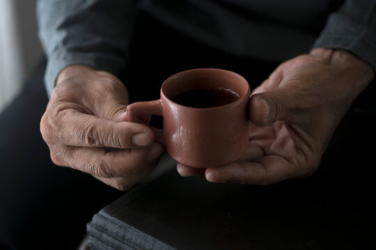 Person holding a small cly cup 
