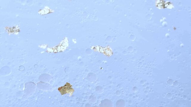 Abstract Science Experiment with Blue Liquid and Gold Particles