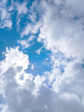 Dramatic Vertical View of Sun Hiding Behind Clouds with Silver Lining Effect