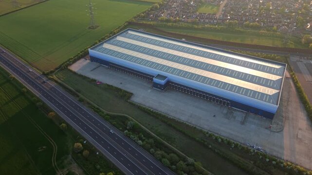 Aerial view of large industrial warehouses in Armthorpe next to a highway during sunset in Doncaster, England, United Kingdom.