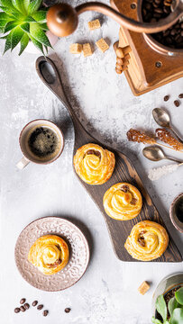Delicious pastries swirl buns with raisins arranged on a wooden board alongside coffee and decorative items, creating a warm and inviting atmosphere, stories templates with copy space