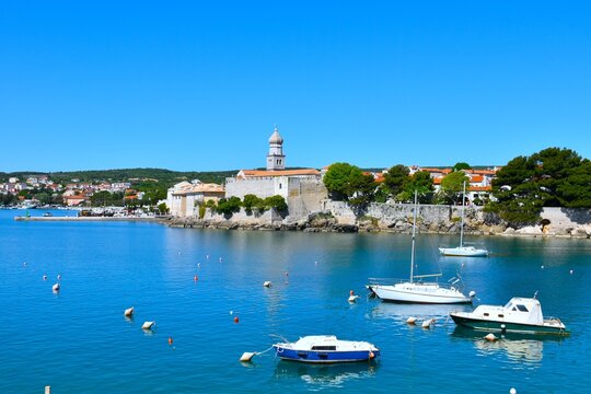 Ancient town of Krk and the Frankopan castle walls at the coast of the Adriatic sea with a church tower above in Kvarner Croatia