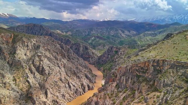 Drone Aerial of Winding River Through Rocky Canyon and Mountains