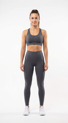Obraz premium Full length portrait of a beautiful fit young woman in stylish sportswear standing straight, isolated on a white background, concept of fitness, healthy lifestyle and body positivity
