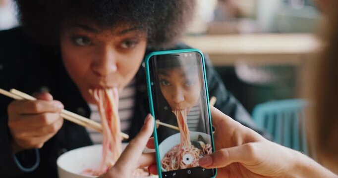 Phone screen, eating or hands with photography in restaurant, food challenge vlog or taste test video. Content creation, influencer or women with mobile to record mukbang, social media post or smile