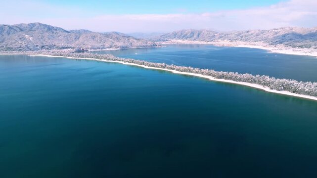 雪景色の天橋立 4Kドローン空撮 日本三景 松並木と青い海のコントラスト