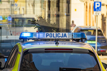 Polish police car with flashing lights in urban street © Alex Malt