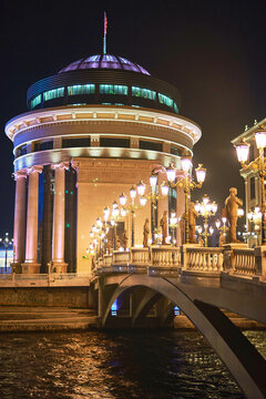 Neoclassical building and the Bridge of Civilizations over the Vardar River at night, Skopje, North Macedonia, Europe.