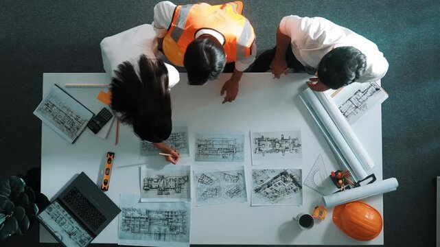 Top down view of smart architect engineer place document at meeting table with safety helmet and plan. Aerial view of business team working together and designing building construction. Alimentation.