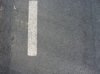 Fototapeta premium gray asphalt road with white painted line, showing simple texture, clean marking, and minimal outdoor surface detail scene