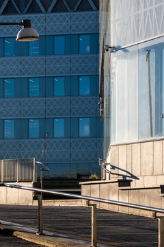Blue glass facade and windows define modern architecture building as walkway space and perspective form clean foreground area for copy and layout