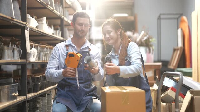 Warehouse workers man with woman using barcode scanner and clipboard checking inventory, Manager and staff discussing WMS software or POS systems, Retail logistics and ecommerce fulfillment concept