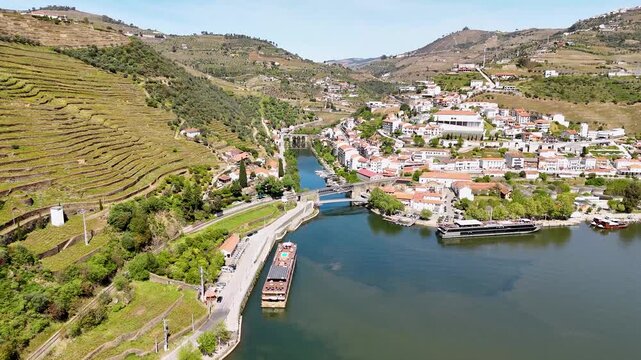 Aerial view of the Douro River with cruise ships and terraced vineyards in Pinhao, Vila Real, Portugal.