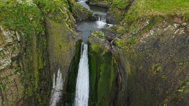 Aerial view of surroundings at Spekes Mill Mouth waterfall which is  located in a beautiful coast area of rugged valleys, high cliffs and wildflowers flourish. Drone POV of United Kingdom landscapes. 