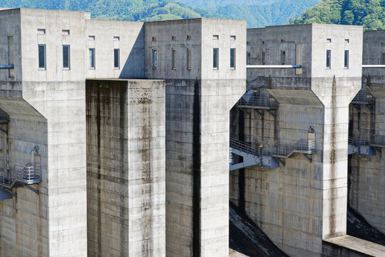 Close Up of Massive Concrete Dam Structure with Maintenance Walkways in Mountain Area