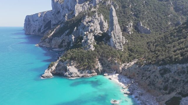 Aerial Panning of Cala Goloritze Beach with Aguglia Limestone Pinnacle and Turquoise Sea Sardinia