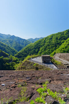 Fresh Green Mountain Valley with Rocky Foreground and Observation Area Under Blue Sky