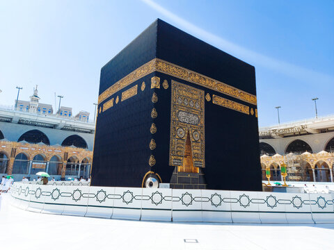 A serene and majestic view of the Kaaba located at the center of Masjid al-Haram. The sacred black cube, adorned with intricate gold-embroidered calligraphy, stands as the spiritual focal point