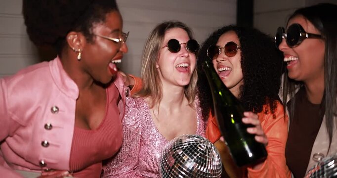 Group of multiracial women dancing, drinking champagne and listening music outdoor - Party, summer and street nightlife concept 