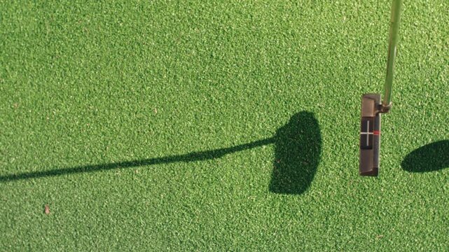 Top down slow motion of a blade putter hitting golf ball on green. Putter ads, golf training videos, and overhead hero shots.