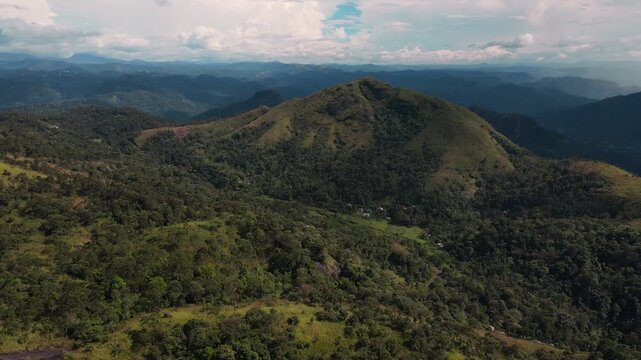 Cinematic drone flyout revealing endless rolling green tea plantation hills and mountain ranges of Munnar Kerala India in lush misty daylight