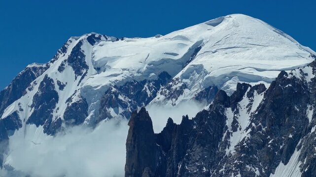 Professional drone footage of the snow capped peaks and rocky ridges of the Mont Blanc massif in Chamonix, France