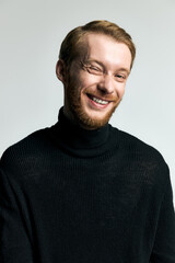 Obraz premium Stylish young man with a charming smile showcasing modern fashion in a minimalist setting