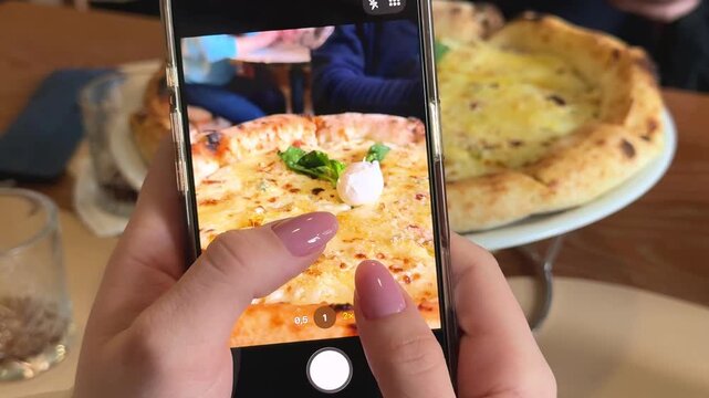girl filming cheese pizza on smartphone food blogging social media content creation 