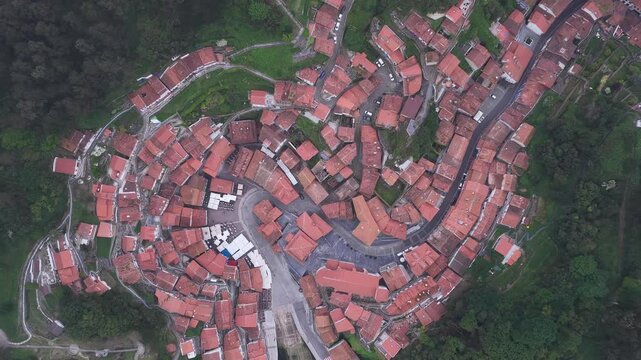 Aerial view of the historic red-tiled rooftops and winding streets in Cudillero, Asturias, Spain.