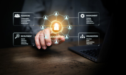 Fototapeta premium Business hand touching glowing leadership icon on virtual HR dashboard with laptop. Teamwork, recruitment, management, organization, talent development, and corporate leadership strategy concept.