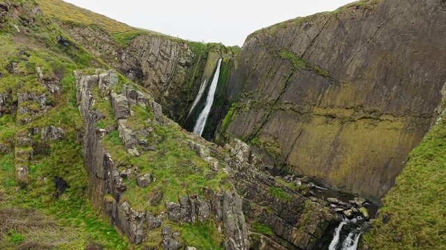 Aerial view of surroundings at Spekes Mill Mouth waterfall which is  located in a beautiful coast area of rugged valleys, high cliffs and wildflowers flourish. Drone POV of United Kingdom landscapes. 
