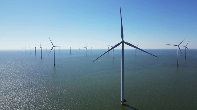 Green energy, wind turbines produce energy in the North Sea, wind farm power plant view from height, alternative energy sources.