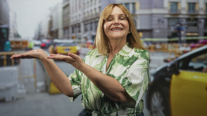 Woman holding palms up in a presenting gesture on a busy city street with yellow taxis and construction barriers  welcoming cheerful. © Krakenimages.com