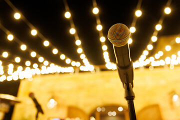 Professional microphone on a stand with festive bokeh lights © 9parusnikov