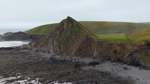 Aerial view of surroundings at Spekes Mill Mouth waterfall which is  located in a beautiful coast area of rugged valleys, high cliffs and wildflowers flourish. Drone POV of United Kingdom landscapes. 