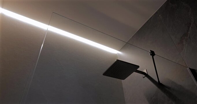 Led shower lighting with square head behind glass in dark stone bathroom, static video shows linear ceiling strip switching on and off to reveal bicolor interior and crisp reflections across wet zone