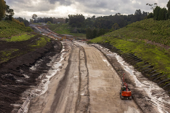 The earthworks of a major road construction project, the Takatimu North Link in the Bay of Plenty, New Zealand. Excavators are parked on the bare soil