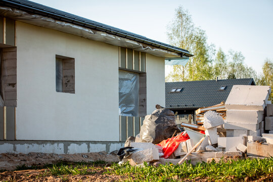 Construction Waste Pile Near House Exterior During Building and Renovation Work