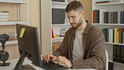 Man at computer and keyboard typing then giving thumbs down at desk with bookshelves in an office building  frustration rejection. © Krakenimages.com