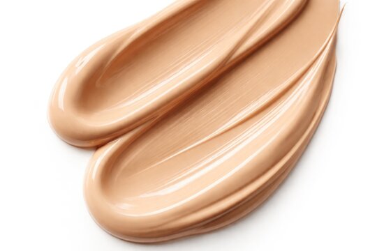Close up of creamy beige foundation product on solid white background