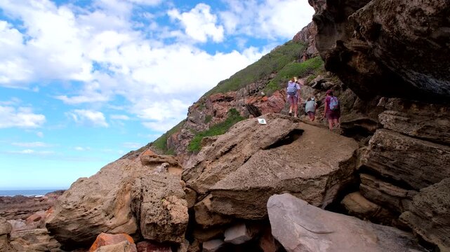 Hikers clamber over boulders along scenic Robberg Nature Reserve peninsula trail
