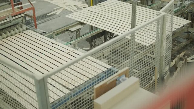 Close-up of human hands applying wood filler to cracks and holes in boards moving on a conveyor for restoration