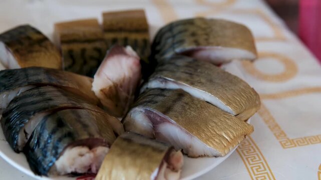 Hot smoked Atlantic mackerel on a wooden surface. Mackerel texture. smoked mackerel pieces on a plate