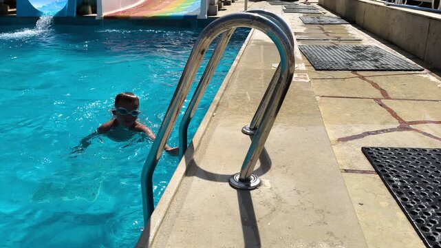 Holiday, kid running and jump in swimming pool for vacation, relax or travel to play at resort outdoor. Boy, child and swimmer dive in water for summer tourism, learning or splash for energy at hotel