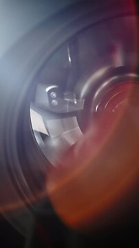 Macro view of a spinning centrifugal compressor turbine impeller inside its circular housing, with curved metallic blades, motion blur, and warm lens flare emphasizing precision aerodynamic